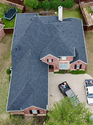 Aerial view of new dark shingle roof installation
